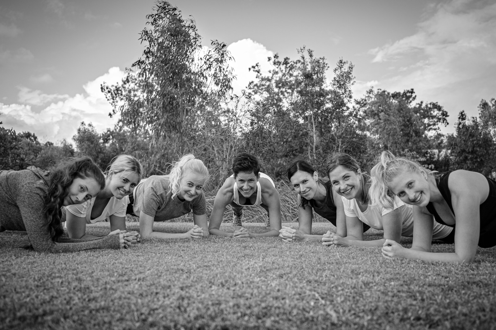 grayscale photo of children on grass field